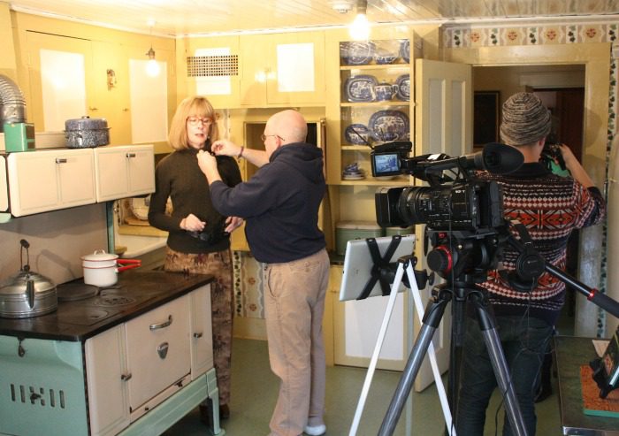 Pamela Smith Hill with Dan Rowland, digital media producer for Missouri State University, prepare to film a lecture in Laura Ingalls Wilder's farmhouse kitchen at Rocky Ridge Farm in Mansfield, Missouri. Also pictured is assistant Drew Mittman.