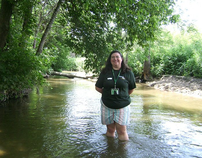 LIWLRA board member Sarah Uthoff wading in Plum Creek