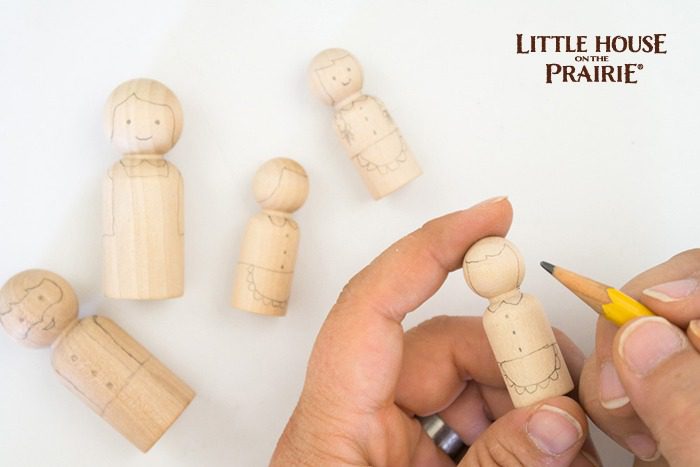 Drawing the simple features onto wooden dolls for homemade toys!